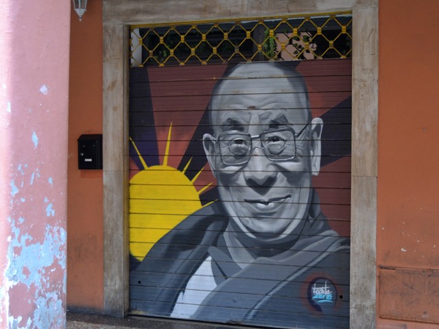 Il Dalai Lama raffigurato sulla saracinesca di un negozio di via del Pratello (BO)