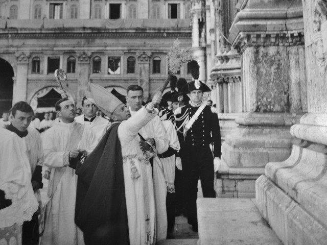 Il card. Lercaro asperge con un ramo d'ulivo il perimetro della basilica di S. Petronio durante la cerimonia di consacrazione 