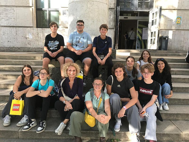 foto di ragazze e ragazzi del gruppo di lettura e accompagnatori in posa sui gradini dell'ingresso della Jugendbibliothek durante la gita a Monaco