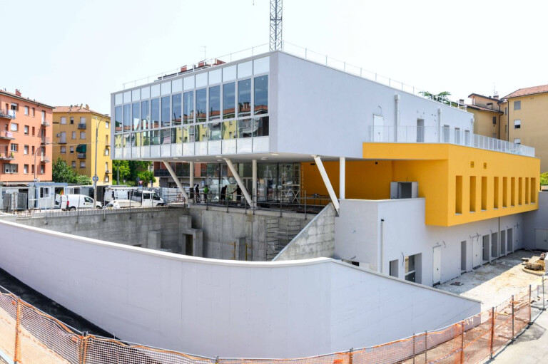 La nuova Casa della Musica negli spazi rigenerati dell’ex Mercato San Donato a Bologna. Edificio ancora in costruzione con facciata vetrata e dettagli gialli.