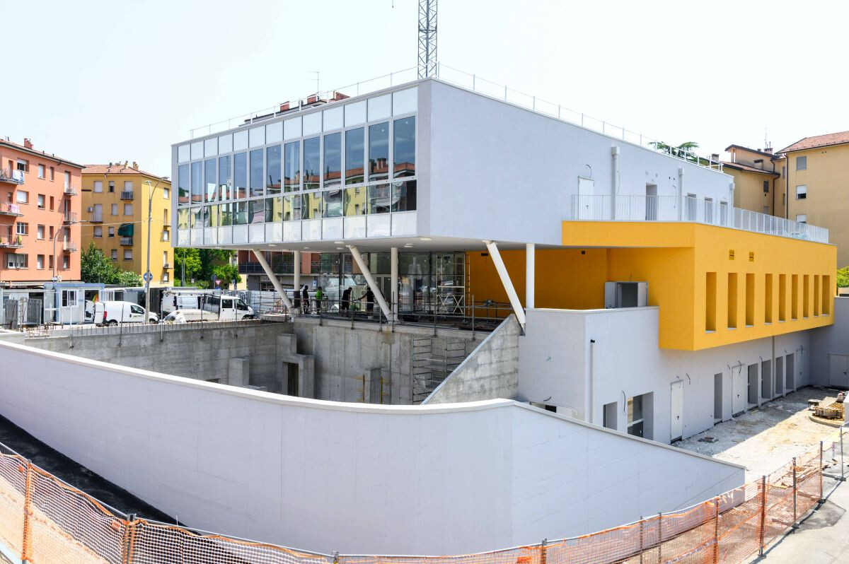 La nuova Casa della Musica negli spazi rigenerati dell’ex Mercato San Donato a Bologna. Edificio ancora in costruzione con facciata vetrata e dettagli gialli.