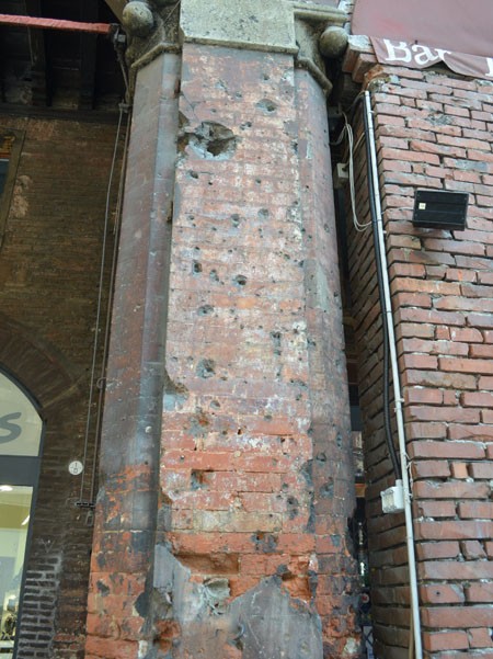 Segni dei bombardamenti su una delle colonne di Casa Seracchioli in piazza della Mercanzia (BO)