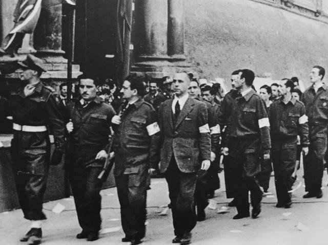 Comandanti partigiani sfilano in Piazza Maggiore - al centro Ilio Barontini - Fonte: Museo della Resistenza - Istituto Parri (BO)