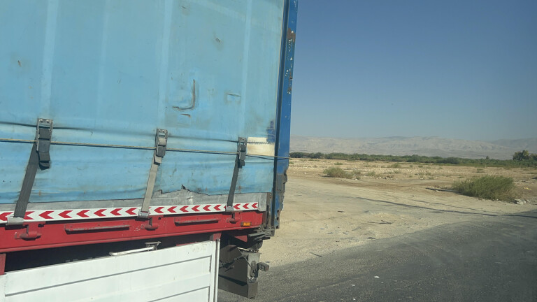 A truck waits at an unacknowledged ”land bridge” border crossing between Jordan and Israel, October 2024