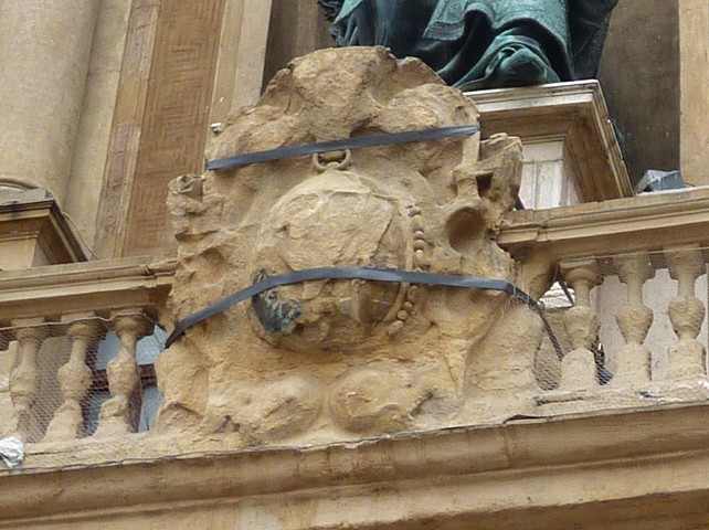Ciò che resta dello stemma in arenaria sul portone d'ingresso del palazzo comunale 